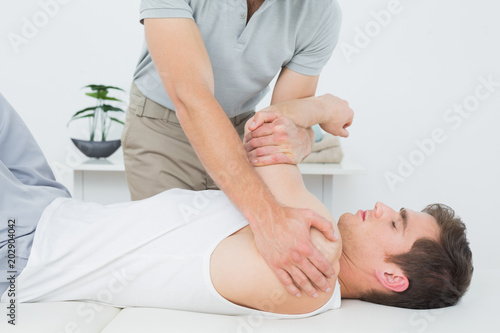 Male physiotherapist examining a mans hand
