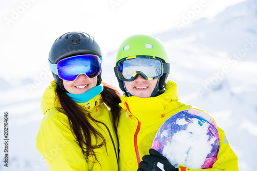 Photo of sports woman and man with snowboard against background of mountains © nuclear_lily