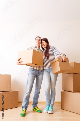 Picture of man and woman standing among cardboard boxes