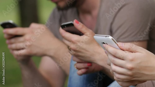 Incomunicability: hands of young people using smartphones- close up photo