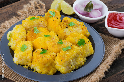 Indian Street Food Khaman Dhokla is a Food Common in The Gujarat State of India Made From Soaked And Freshly Ground Channa Dal or Channa Flour on Wooden Background