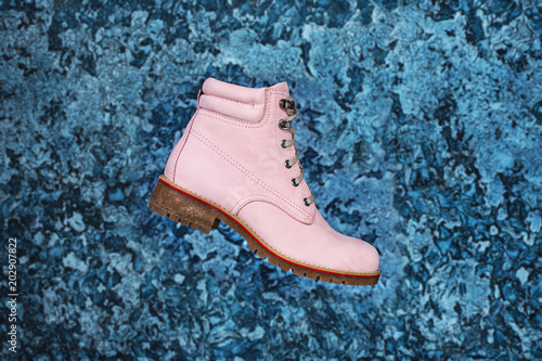 Women's pink suede boots on a shiny decorative background of auqa blue plaster. Fashion advertising shoes photos. photo