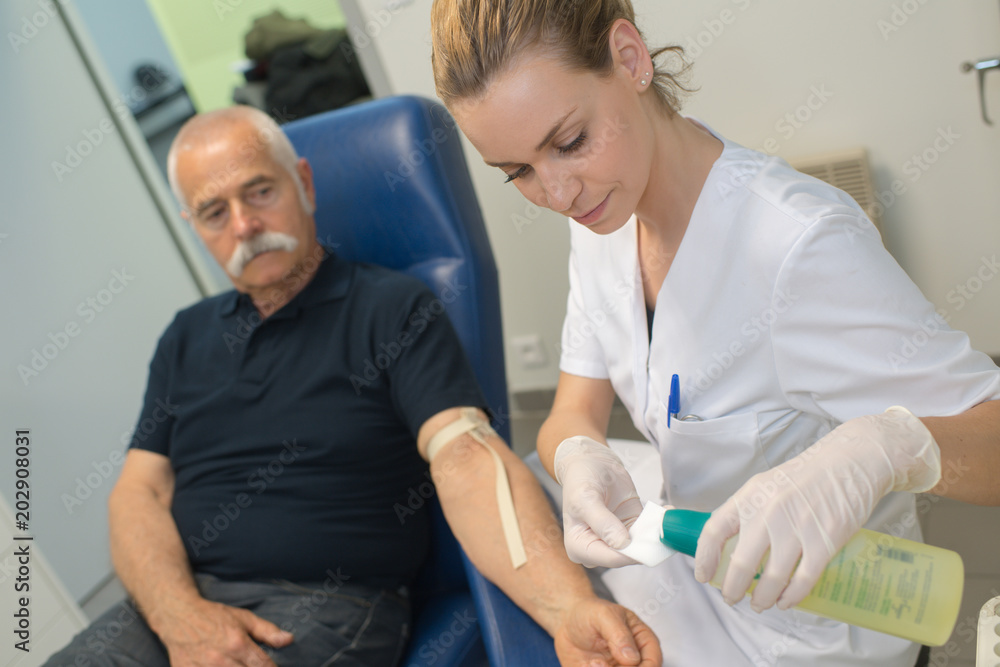 Fototapeta premium doctor testing blood to a senior patient