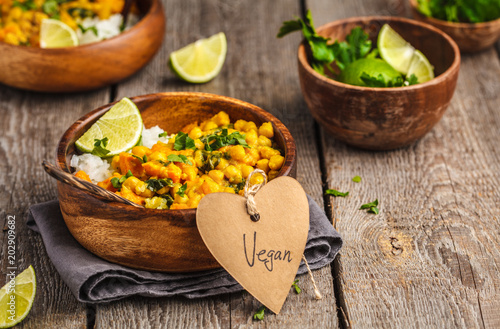 Vegan Sweet Potato Chickpea curry in wooden bowl on a wooden background. Healthy vegan food concept.