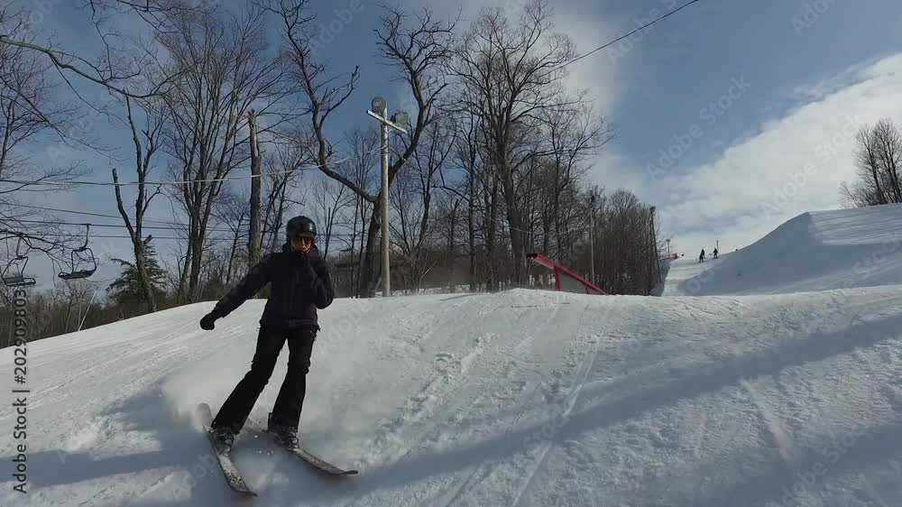 Female Freestyle skiier grinds handrail - head on shot Female Freestyle skiier grinds handrail - head on shot