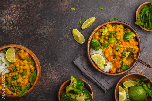 Vegan Sweet Potato Chickpea curry in wooden bowl on a dark background, top view. Healthy vegetarian food concept.