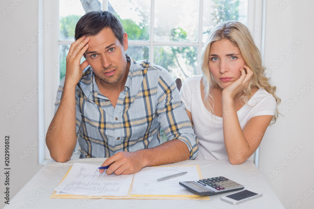 Worried couple with financial documents and calculator Worried couple with financial documents and calculator