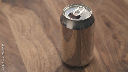 open aluminium can with soda drink on wood table