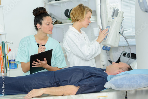 doctor looking at female patient going through ct scan