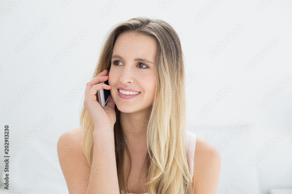 Smiling young woman using cellphone in bed Smiling young woman using cellphone in bed