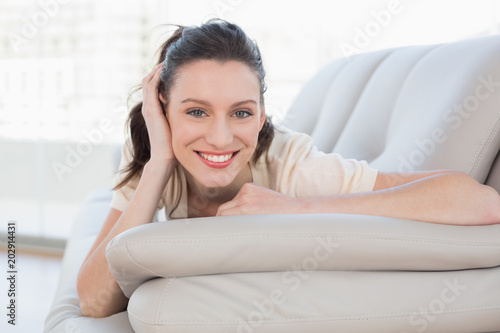 Portrait of a smiling casual woman lying on sofa