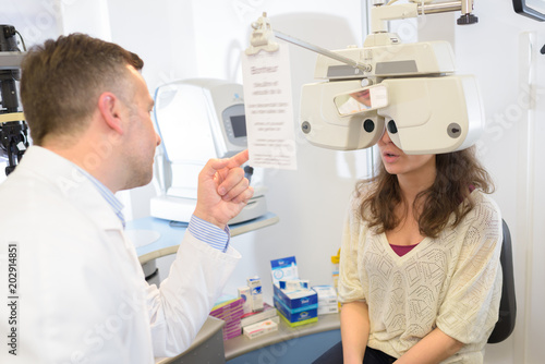 Fototapeta Naklejka Na Ścianę i Meble -  male optometrist doing sight testing for female patient