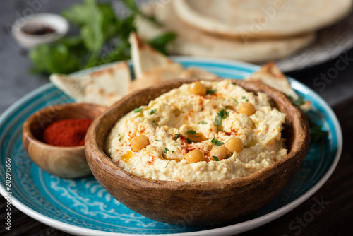 Traditional chickpea hummus in bowl, pita and paprika. Healthy vegan spread, arabic food. Selective focus.
