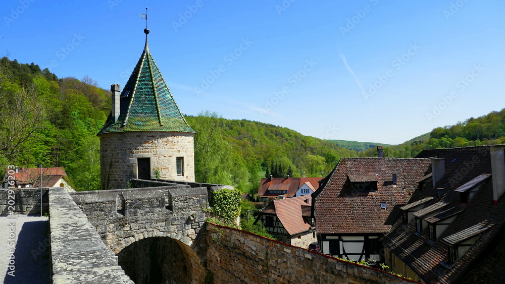 grüner Turm des Klosters Bebenhausens mit  Wehrmauern vor blauem Himmel im Frühling
