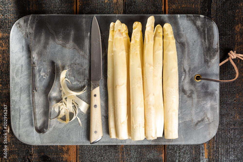 Top view, fresh tasty white asparagus, seasonal vegetable, new harvest,  with piller and knife, ready to cook, Stock Photo