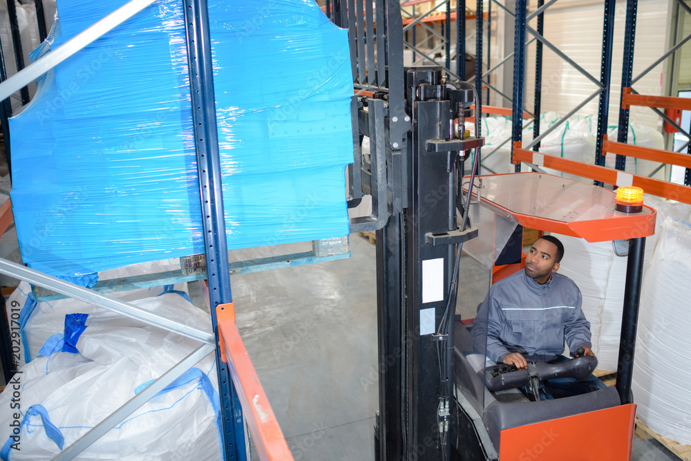 man on forklift loader loading boxes at warehouse man on forklift loader loading boxes at warehouse