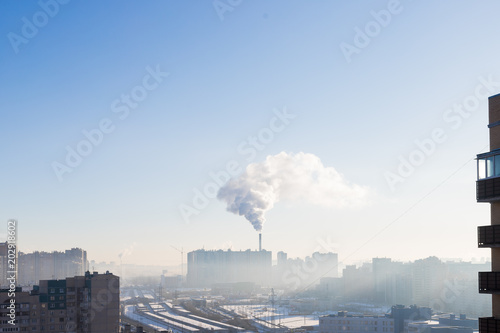Urban landscape smoked polluted atmosphere from emissions of plants and factories, view of pipes with smoke and residential apartment buildings.Ecology concept