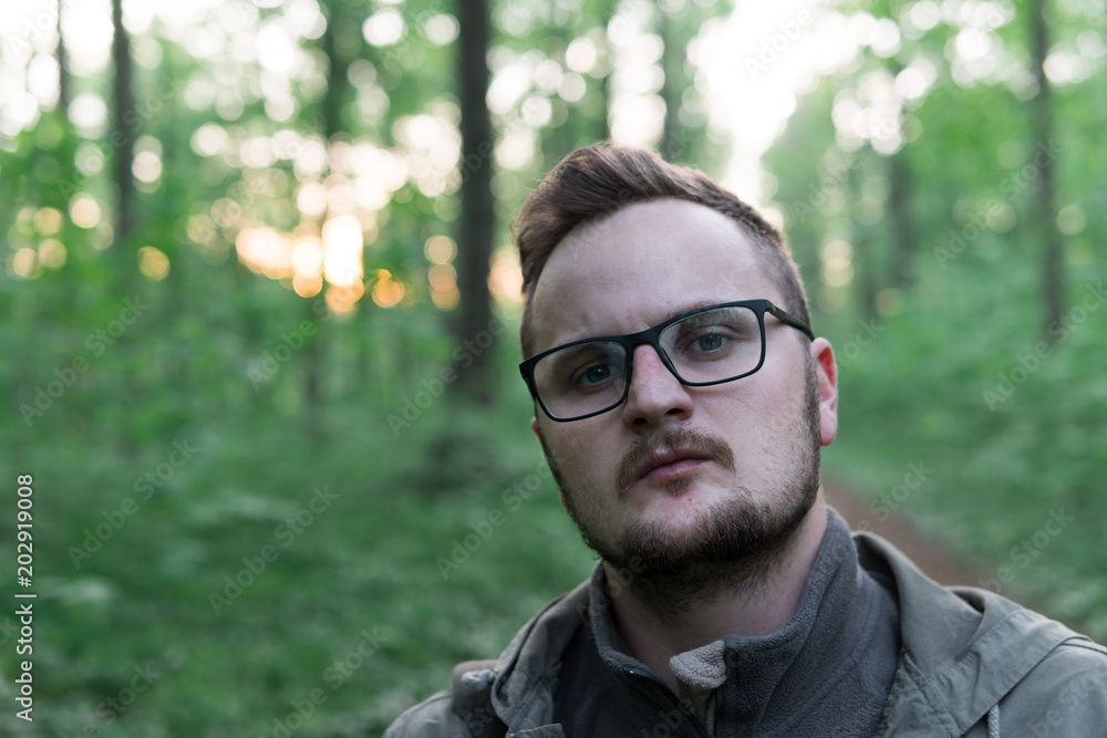 man with glasses standing on the forest path of the park and looking in camera, active lifestyle concept, sport and jorney, travel surviver concept man with glasses standing on the forest path of the park and looking in camera, active lifestyle concept, sport and jorney, travel surviver concept