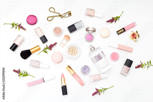 Set of cosmetics on a white background and twigs of flowers. Flat lay