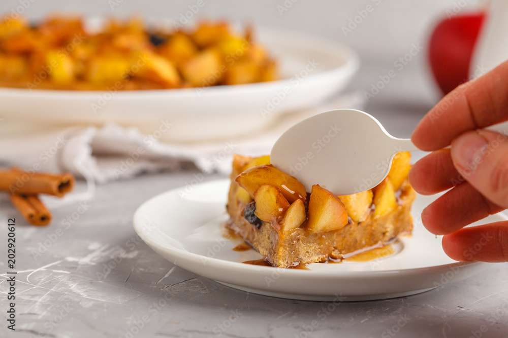 Piece of vegan apple pie with cinnamon, raisins and caramel, gray background. Piece of vegan apple pie with cinnamon, raisins and caramel, gray background.