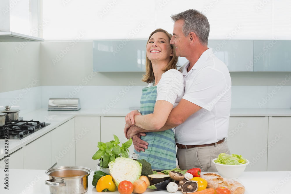 Side view of a man embracing woman in kitchen Side view of a man embracing woman in kitchen
