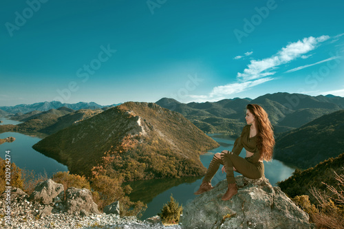 Girl tourist enjoying and sightseeing amazing view of Rijeka Crnojevica, Montenegro. Skadar lake national park, Pavlova Strana. Viewpoint Ridge mountains panoramaic landscape.