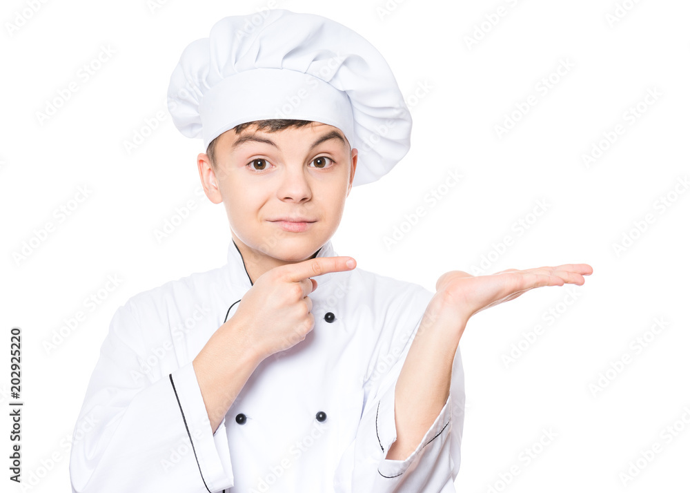 Handsome teen boy wearing chef uniform. Portrait of a happy cute male child cook pointing on copy space, isolated on white background. Food and cooking concept. Handsome teen boy wearing chef uniform. Portrait of a happy cute male child cook pointing on copy space, isolated on white background. Food and cooking concept.