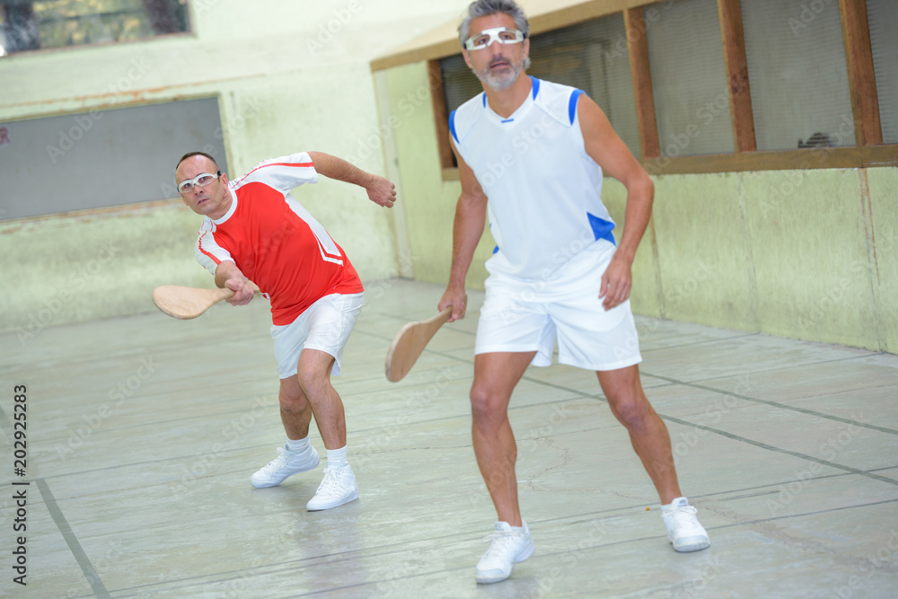 Men playing a racket sport Men playing a racket sport