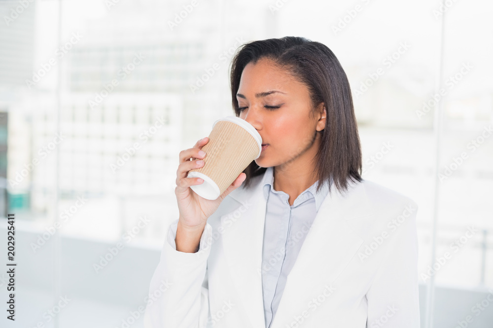 Cute young dark haired businesswoman enjoying coffee Cute young dark haired businesswoman enjoying coffee