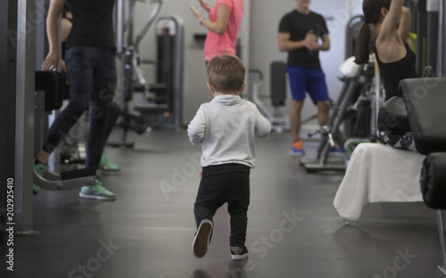 little boy in a sport suit running in the gym