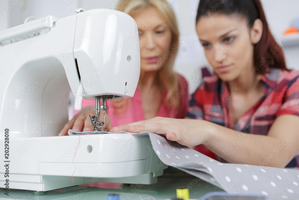 Fotografie teaching the daughter to sew