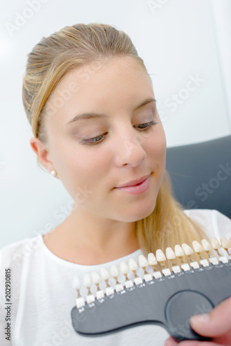 Lady looking at teeth samples in dental surgery