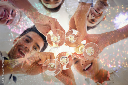 Casual business team toasting with champagne against colourful fireworks exploding on black background