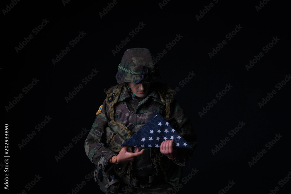 Toy soldier holding folded American flag