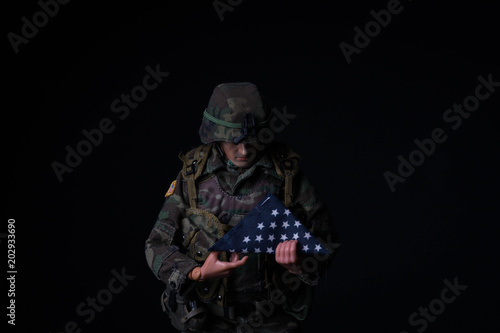 Toy soldier holding folded American flag