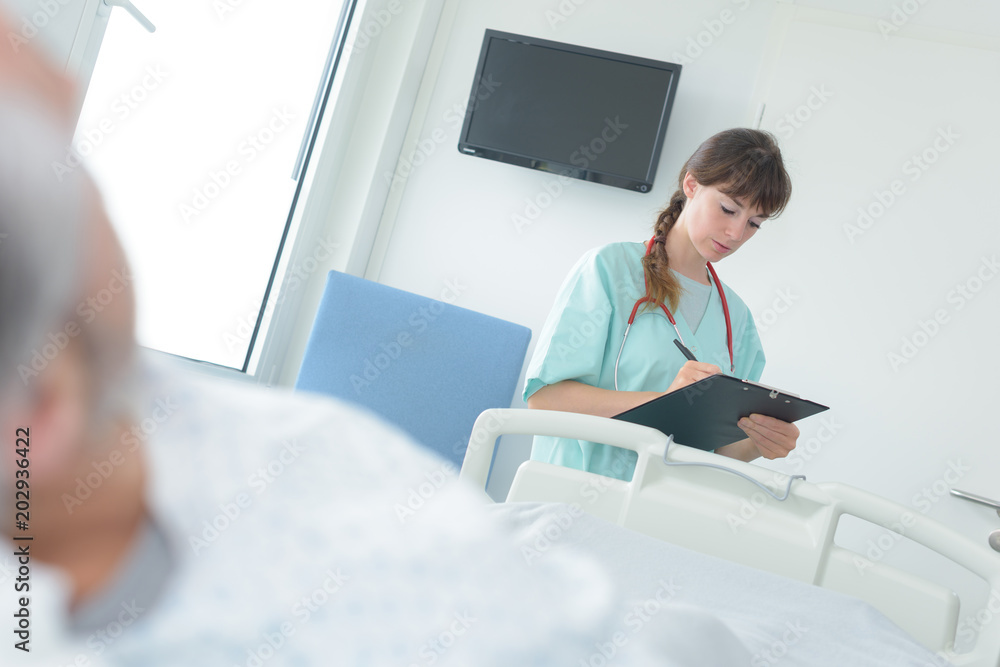 nurse writing the patients status nurse writing the patients status