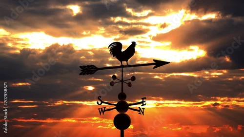 Weathervane cockerel floating against red sunset
