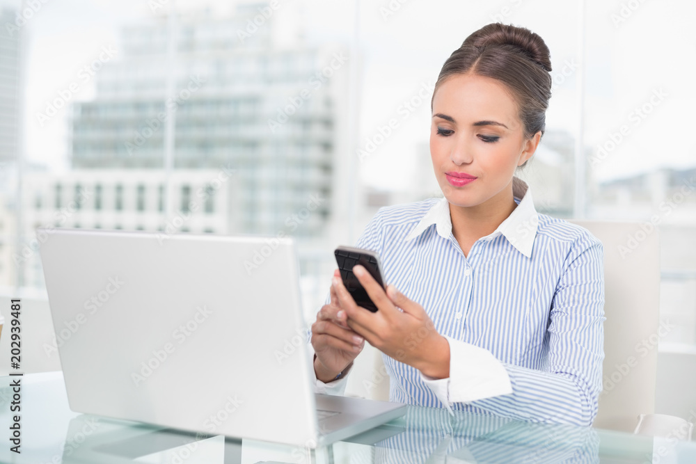 Content brunette businesswoman looking at smartphone Content brunette businesswoman looking at smartphone