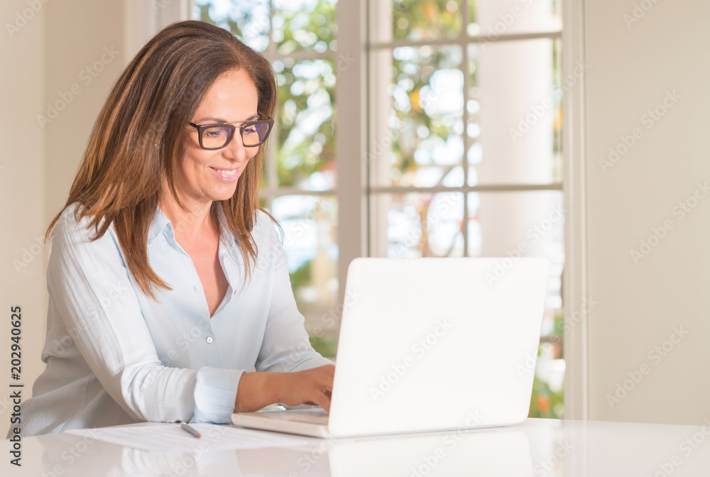 Middle age woman using laptop computer, indoor Middle age woman using laptop computer, indoor