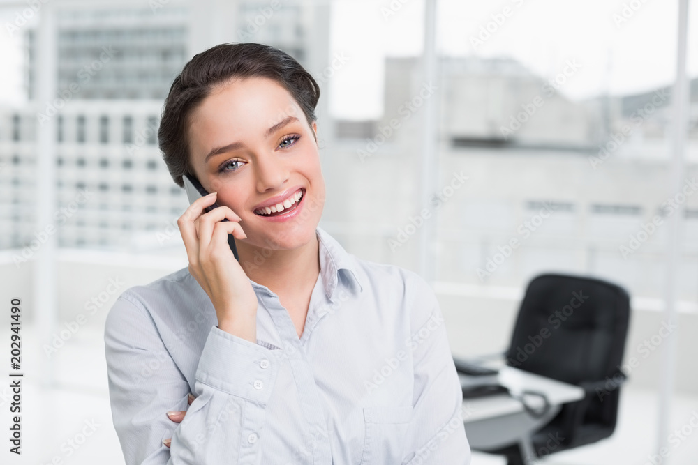 Smiling businesswoman using cellphone in office Smiling businesswoman using cellphone in office