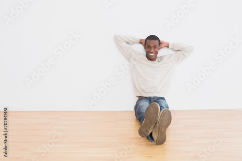Afro young man sitting on floor in an empty room