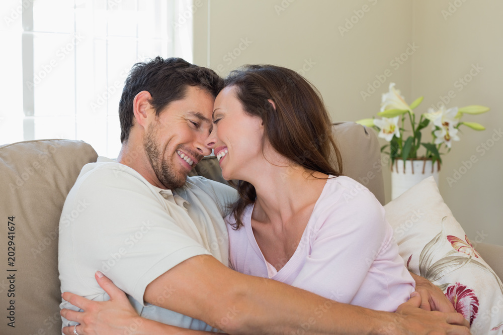 Cheerful loving couple on couch at home