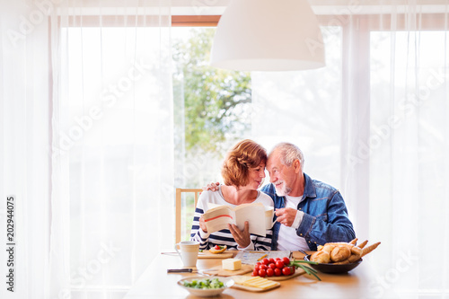 Senior couple eating breakfast at home.