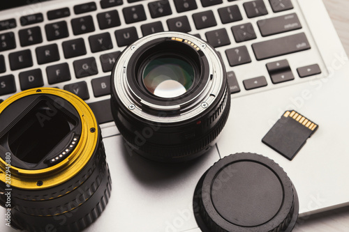 Photo camera lenses and memory card on computer