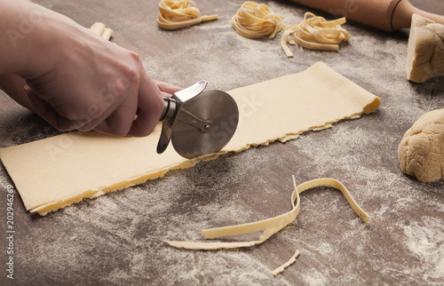 Chef using wheel cutter in preparation of pasta photo