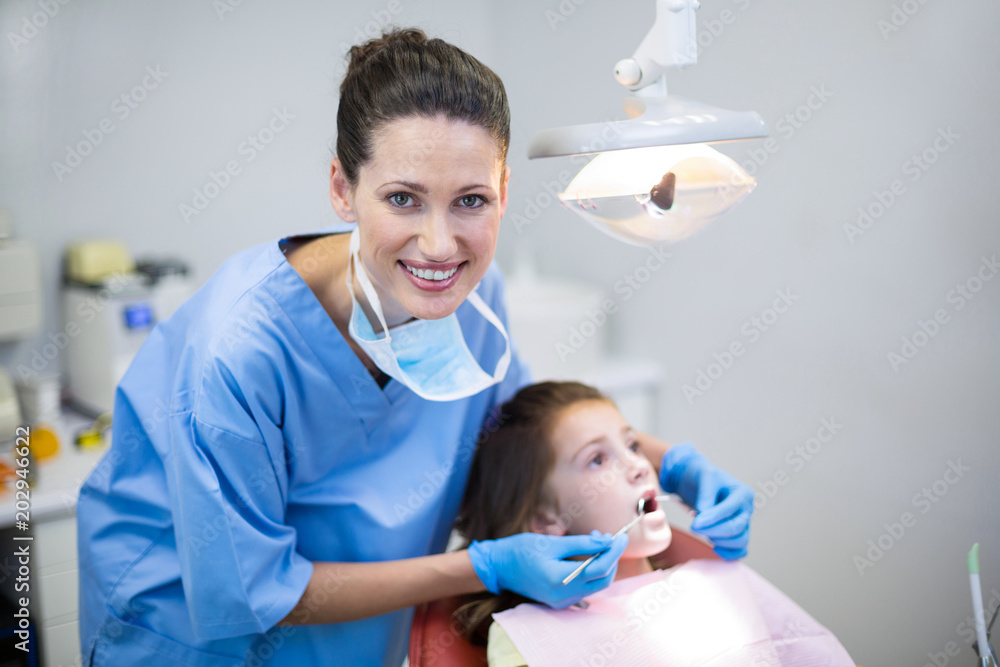 Dentist examining a young patient with tools in dental clinic Dentist examining a young patient with tools in dental clinic