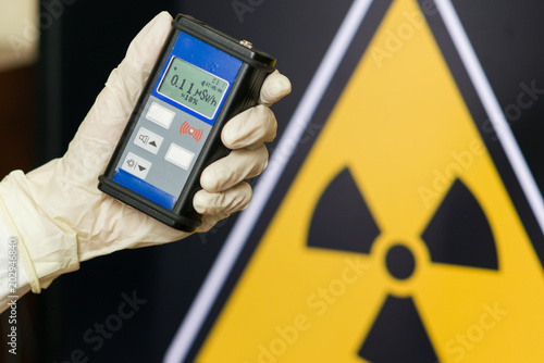 Radiation supervisor in glove with geiger counter checks the level of radiation photo