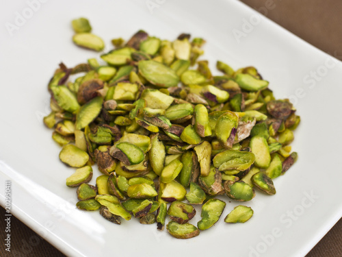Sliced green pistachios on a white plate