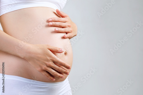 Slika na platnu Young pregnant woman caress belly.