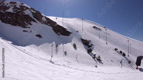 4K. Aerial view of a snowy rocky mountain. Beautiful and sunny day with blue sky. Sierra Nevada, Spain-Adrian.